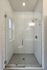 Elegant walk-in shower with sleek glass doors and modern subway tile design.