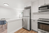 Modern kitchen with sleek stainless steel appliances and bright dining area perfectly lit by elegant floor lamp.