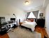 Inviting bedroom with a cozy bed, elegant workstation, and warm natural lighting creating a perfect atmosphere for relaxation and productivity.