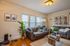 Inviting living room with cozy gray sofas, vibrant artwork, and a lush indoor plant, perfect for relaxation.
