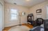 Bright and inviting home office featuring a chic lamp, stylish decor, and a cozy carpeted floor.