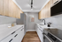 Modern kitchen with sleek wooden cabinets, integrated appliances, and elegant lighting, emphasizing style and functionality.