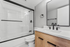 Modern bathroom featuring sleek fixtures and a stylish glass shower with elegant black accents.