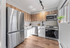 Modern kitchen with sleek stainless steel appliances, elegant wooden cabinets, and abundant natural light creating a warm ambiance.
