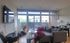 Bright and modern living space featuring a cozy sectional sofa, sleek wall-mounted TV, and large windows with natural light.