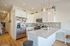 Bright, modern kitchen with quartz countertops, stainless steel appliances, and elegant pendant lighting.
