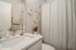 Modern bathroom with elegant sink, stylish circular mirrors, and bright accents, creating a serene atmosphere.