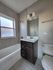Modern bathroom featuring a bright window, sleek vanity with mirror, and elegant fixtures, offering a serene and refreshing atmosphere.