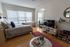 Charming apartment bedroom with large windows, cozy bed, stylish decor, and inviting workspace.