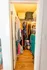 Charming walk-in closet with ample storage featuring wooden floors, vibrant clothing, and a stylish turquoise dresser.