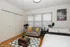 Charming bedroom featuring cozy seating area, elegant decor, and abundant natural light from large windows.