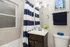 Chic bathroom with modern fixtures, striped shower curtain, and stylish decor.