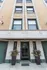 Charming historical building facade with decorative stonework and elegant green entrance doors, perfect for city living.