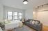 Bright and cozy studio apartment with modern decor, featuring a comfortable bed, elegant sofa, and large windows offering ample natural light.