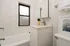 Bright and modern bathroom with elegant white tiles, sleek vanity, and a refreshing ambiance perfect for relaxation.