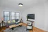 Bright, modern living room featuring a cozy grey sofa, stylish coffee table, and large window for ample natural light.