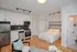 Chic studio apartment showcasing an open-plan design, featuring a modern kitchen with stainless steel appliances, a cozy sleeping area, and stylish decor.