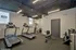 Modern fitness center featuring treadmills, a weight bench, and free weights in a stylish industrial design.