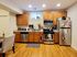 Charming kitchen with wooden cabinets, granite countertops, and modern stainless steel appliances, ideal for culinary enthusiasts.