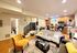 Charming open-plan living area featuring a stylish kitchen with wooden cabinetry, cozy seating, and modern lighting.