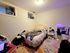 Cozy bedroom featuring a plush bed, elegant lighting, and a chic decorative mirror, perfect for a restful retreat.