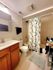 Bright and inviting bathroom with modern fixtures, elegant wood cabinetry, and a charming floral shower curtain.