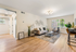 Bright and inviting living room with modern decor, wooden flooring, and ample natural light streaming through large windows.