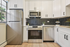 Modern kitchen with sleek stainless steel appliances, elegant white cabinetry, and stylish black hexagonal tile backsplash.