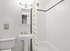 Elegant bathroom with modern fixtures, featuring a clean white color scheme, stylish pedestal sink, and artistic shower curtain.