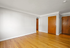 Bright and inviting room with polished hardwood floors and warm wood doors, perfect for creating a cozy living space.