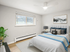 Bright and cozy bedroom with a modern bed, stylish pillows, and a large window inviting natural light, creating a warm and inviting atmosphere.