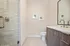 Contemporary bathroom with sleek vanity, elegant glass shower, and modern fixtures, exuding stylish simplicity.