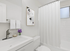 Bright modern bathroom with sleek fixtures, elegant artwork, and refreshing natural light.