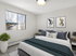 Bright and cozy bedroom featuring a stylish double bed, elegant artwork, and a view through a large window, perfect for relaxation.