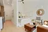 Chic studio apartment with stylish decor, featuring a cozy bed, elegant mirror, and tasteful art pieces, complemented by modern furniture and warm lighting.