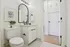 Chic modern bathroom showcasing elegant black and white decor, featuring a stylish curved mirror, sleek fixtures, and ambient lighting.