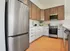 Modern kitchen with stainless steel appliances, sleek cabinetry, and elegant wooden flooring.