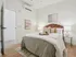 Inviting bedroom with elegant decor, featuring a plush bed with stylish pillows, soft lighting, and modern artwork; perfect for relaxation.