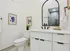 Elegant bathroom featuring a modern vanity with a sleek black faucet, large arched mirror, and stylish decor pieces creating an inviting atmosphere.