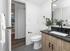 Modern bathroom with sleek black fixtures, wooden cabinetry, and a large mirror, exuding elegance and style.