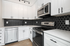 Sleek modern kitchen featuring stainless steel appliances, elegant white cabinetry, and a chic hexagon backsplash.