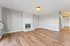 Elegant living room with bright natural light, featuring a stylish brick fireplace and modern wood flooring.