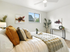 Inviting bedroom with cozy bedding, stylish decor, and natural light from a large window.