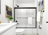 Modern bathroom with sleek black fixtures, elegant glass shower doors, stylish abstract art, and a vibrant potted plant for a refreshing touch.