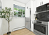 Modern kitchen with sleek appliances, black hexagonal backsplash, and bright natural light from large window.