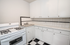 Charming kitchen with vintage-style gas stove, sleek checkered flooring, and ample white cabinetry.