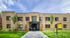Elegant two-story brick apartment building with modern entrance, lush green lawn, and inviting sidewalk, embodying suburban charm and comfort.