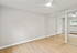 Bright and airy bedroom featuring elegant wooden flooring and mirrored closet doors.