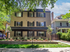Charming three-story apartment building with modern design and lush landscaping, nestled in a serene neighborhood.