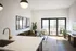 Bright and inviting living room with a modern kitchen island, elegant furnishings, and a large balcony providing ample natural light.